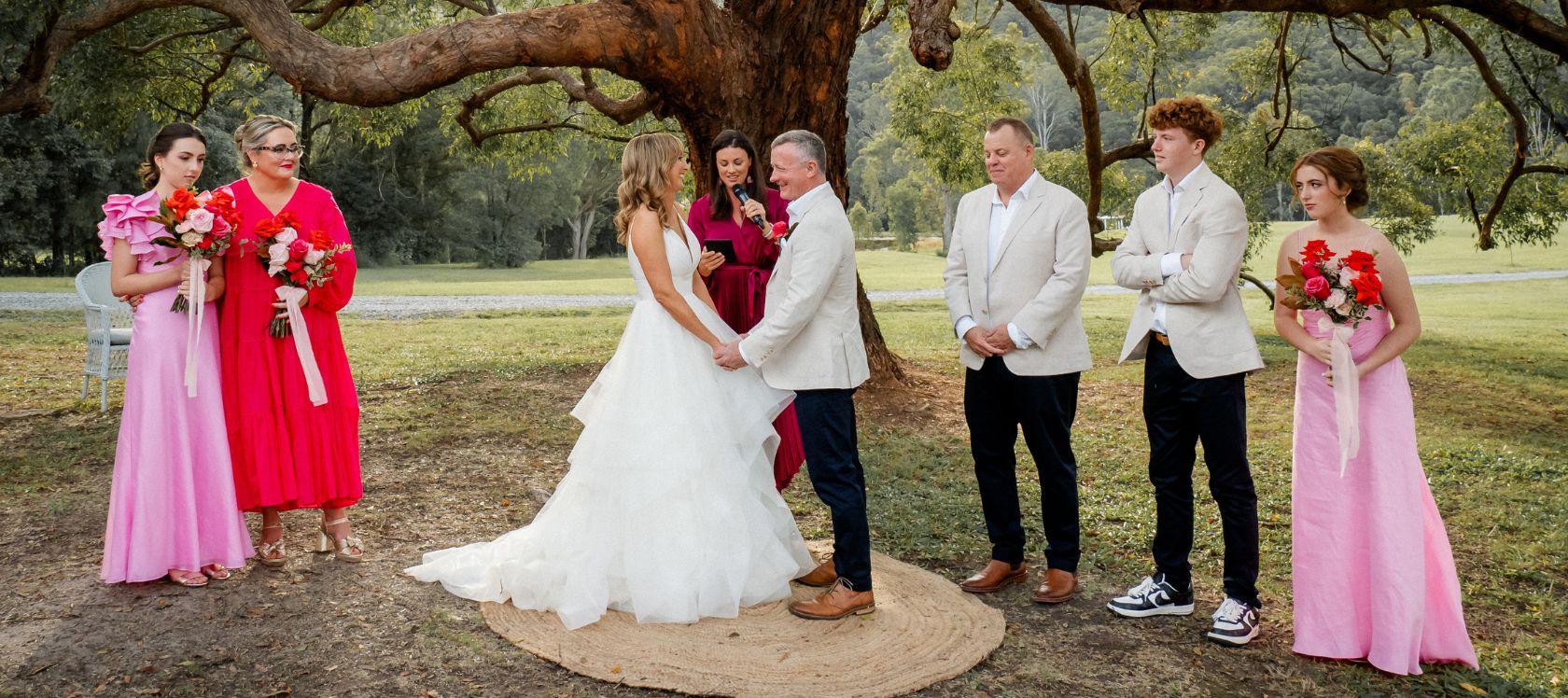 Wedding ceremony with bride and groom, wedding party and celebrant.