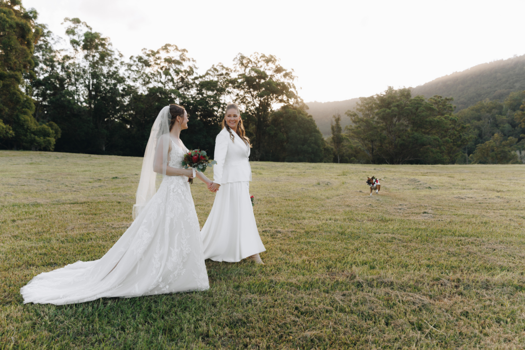 Two brides stand on a field for their wedding on the Gold Coast