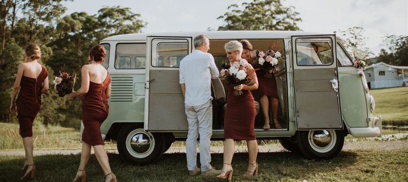 Wedding party arrive in vintage sage green combi van