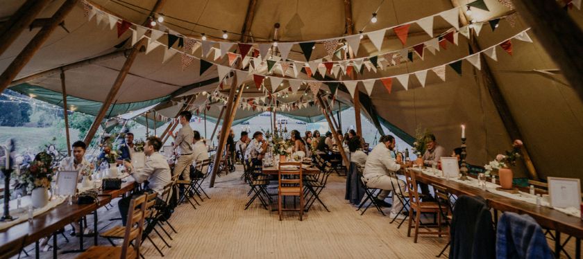 Wedding reception under the tipi with guests and decor