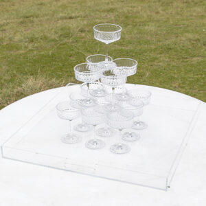 White clear tray holds champagne tower on a white round table