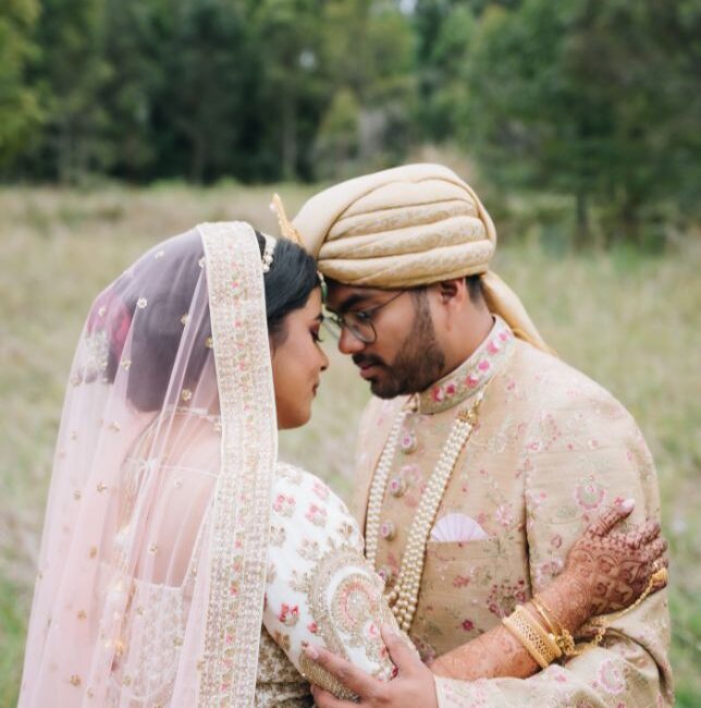 Couple wearing traditional Bangladeshi dress gently embrace one another