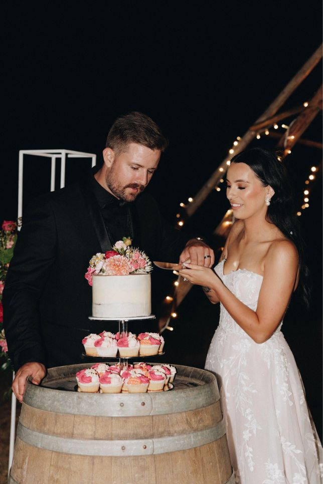 Newly wed bride and groom cut the cake at their reception