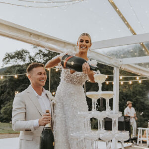 married couple at their gold coast reception pouring champagne tower