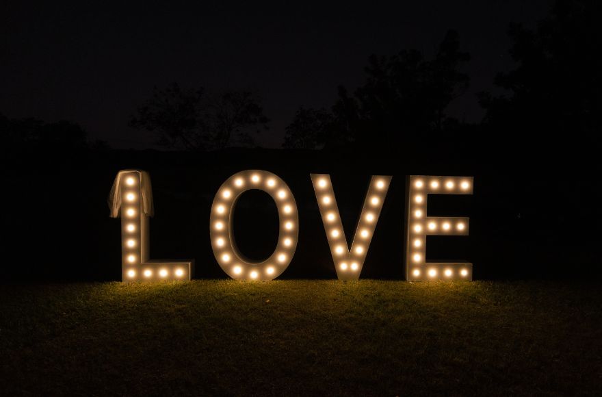 An illuminated sign spelling LOVE, lights the farm at night