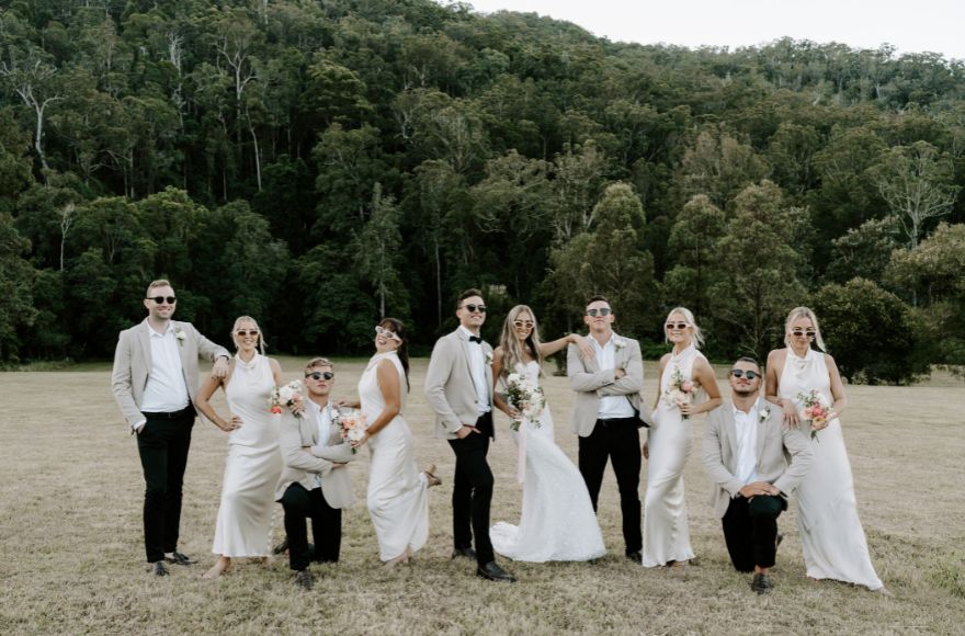 Wedding party poses for humorous fun photo on the grounds of the farm.