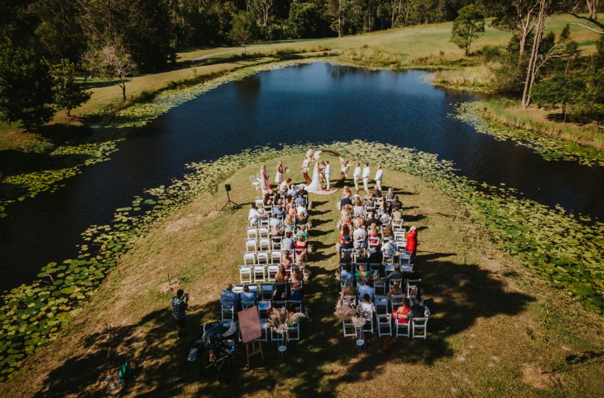 Aerial view of a wedding ceremony set up at the point of the lake