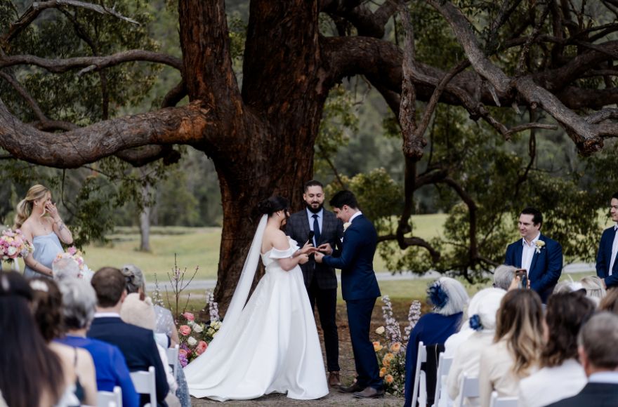 Bride and groom have their wedding ceremony under the 100 year old tree on the farm