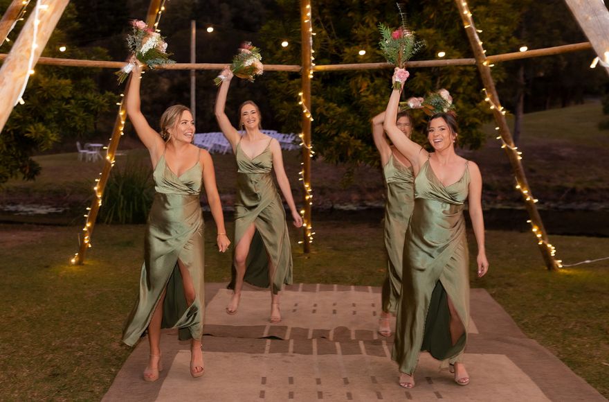 Four bridesmaids perform a choreographed dance under the naked tipi