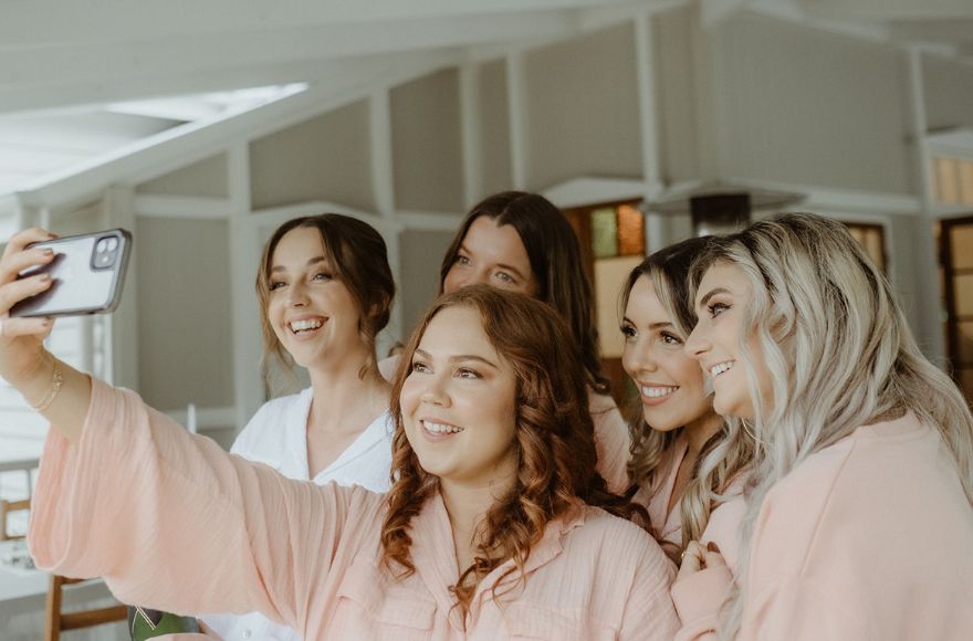 5 women dressed in matching sleepwear take a selfie together 