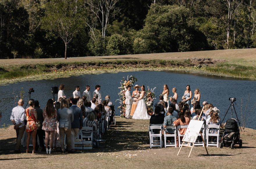 Wedding ceremony by the lake at the Gold Coast Farm House.