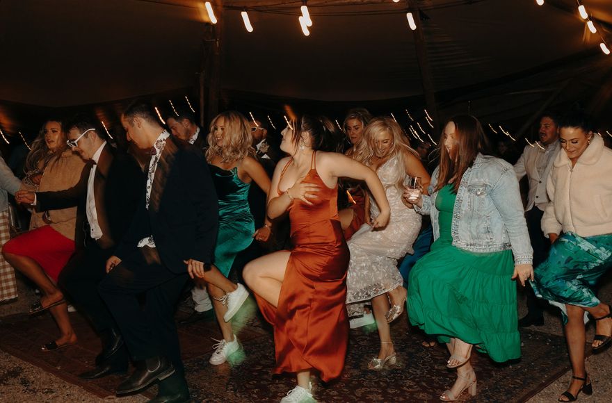 Wedding guests dance in sync on a dancefloor