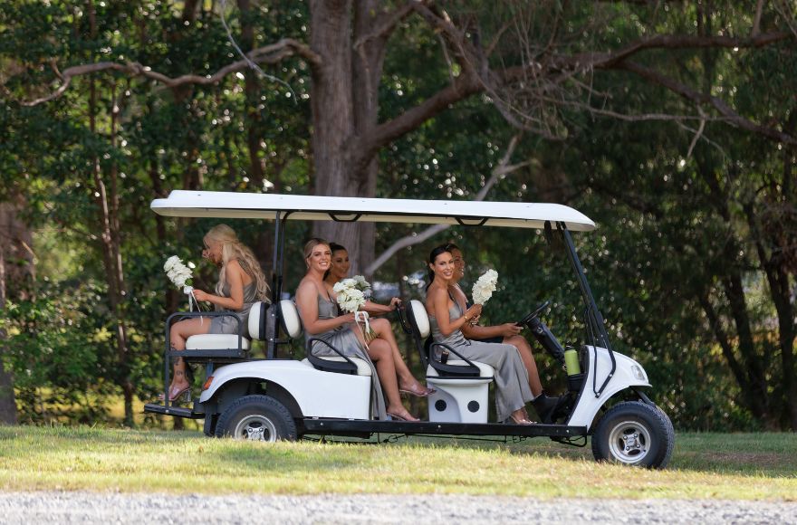 Bridesmaids are transported around the grounds of the Farm House on a deluxe golf buggy