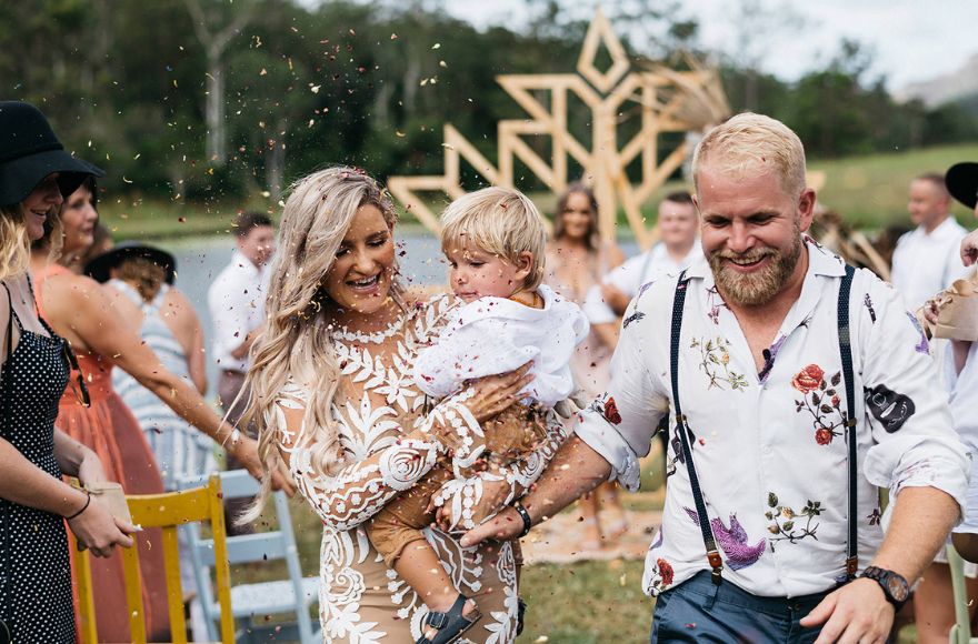 Newly wed couple and their toddler are showered with dried flower confetti 